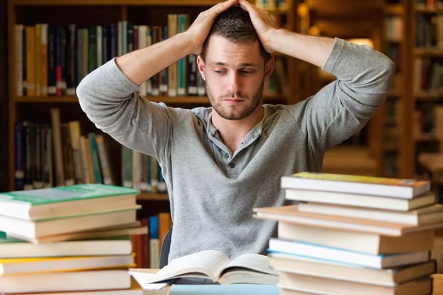 Male college student stressed books library S.width .jpg