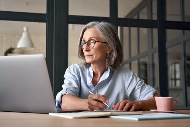 a person at a laptop holding a pen gettyimages .jpg