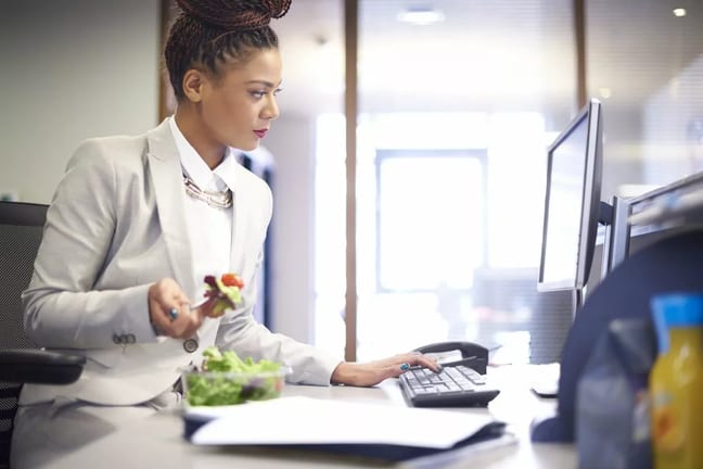 woman eating salad at work rCJmRBb.width .jpg