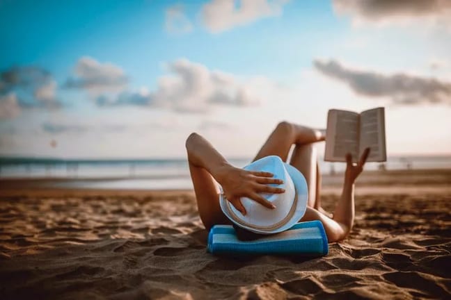 woman reading on beach TUtTQeI.width .jpg