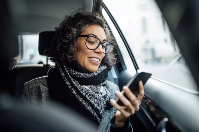 person sitting in a car looking at a phone.jpg