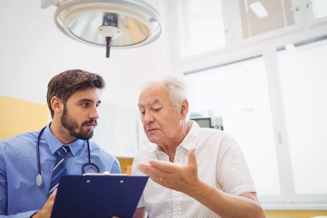 senior man talking to doctor holding clipboard medical expenses healthcare hospital.jpg