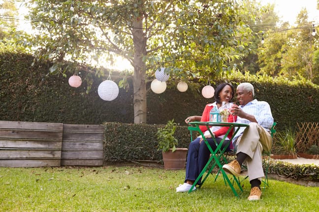 mature couple relaxing drinking wine together in their backyard.jpg