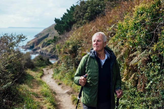 person hiking on trail by a body of water.jpg