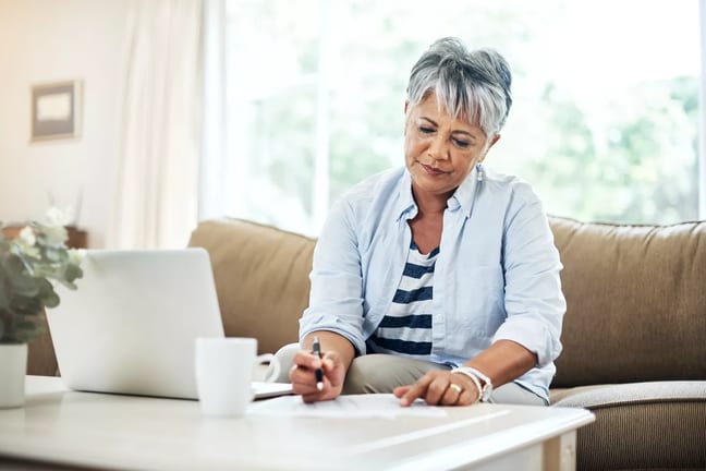 person holding pen and looking at document on coffee table.jpg