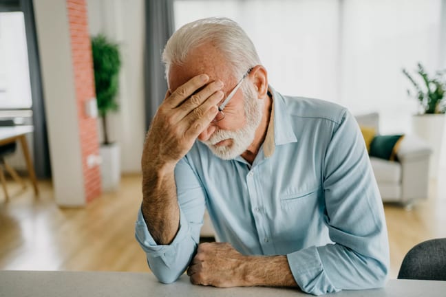 senior man holding face gettyimages .jpg