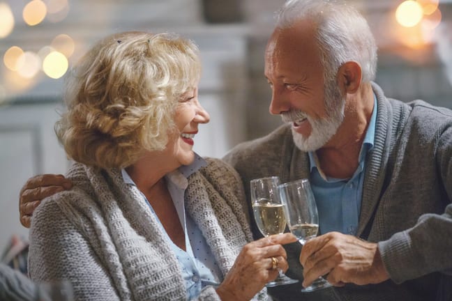 smiling seniors clinking champagne glasses together.jpg
