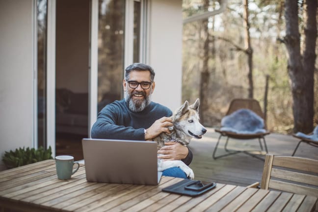 older man at laptop with dog gettyimages .jpg