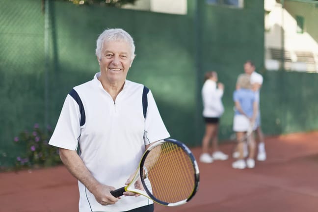 older man holding tennis racket gettyimages .jpg
