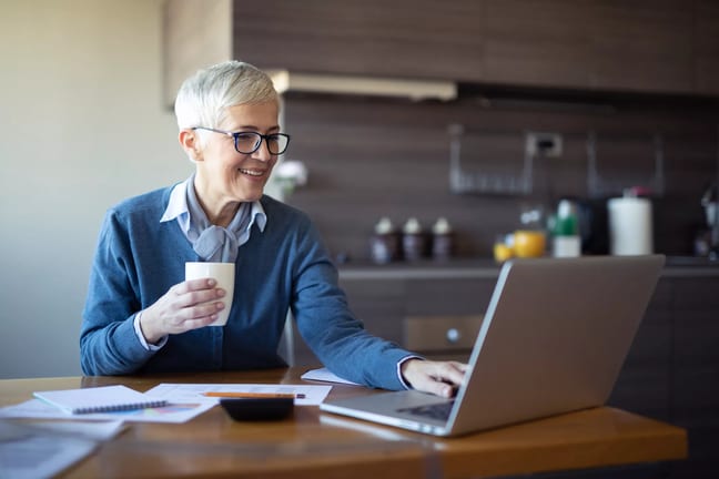 older person looking at a laptop and smiling.jpg