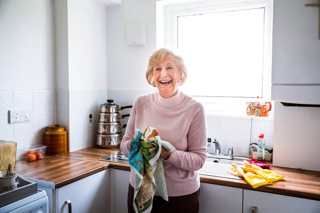smiling person drying hands on towel in kitchen.jpg