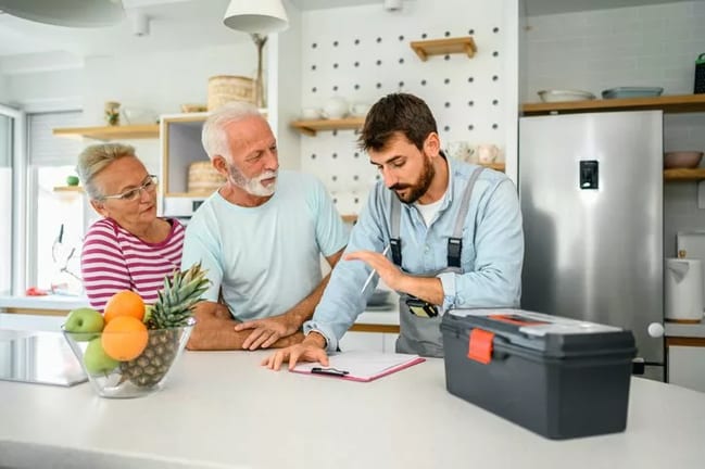 repairman talks to couple in kitchen KLkHSy.width .jpg