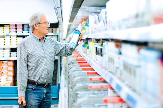 Mature man reads the label on a milk carton i.width .jpg