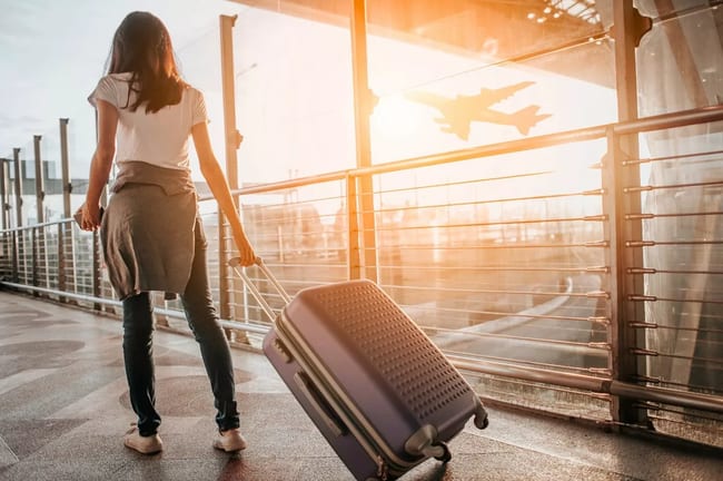 woman with suitcase in airport kihmYKH.width .jpg