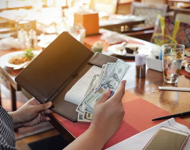 paying restaurant check with cash.width .jpg