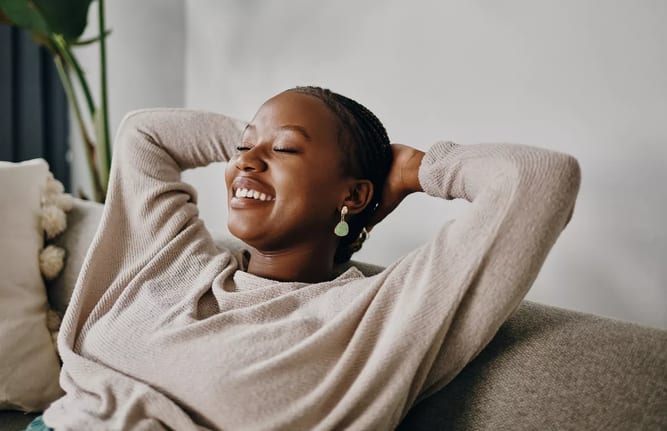 relaxed person sitting on couch with hands behind head.jpg
