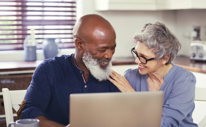 smiling mature couple using laptop at home.jpg