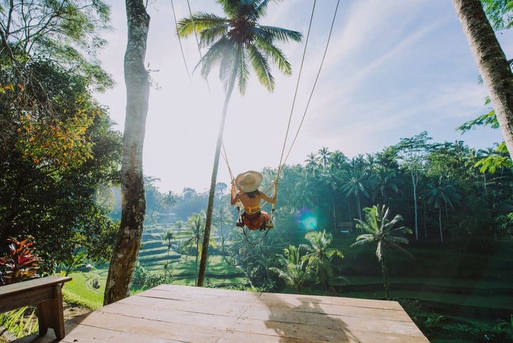 woman on swing in tropical vacation.width .jpg