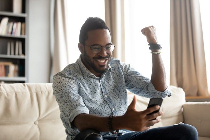 happy man with phone pumping fist dWwY.width