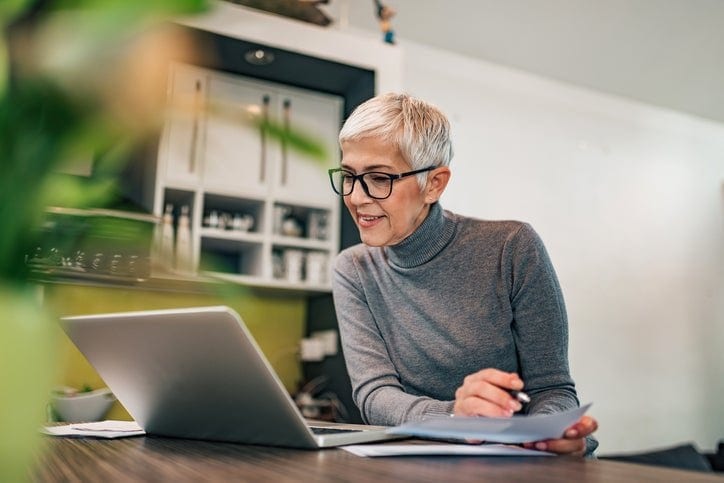 woman at home with laptop and paperwork iLty.width