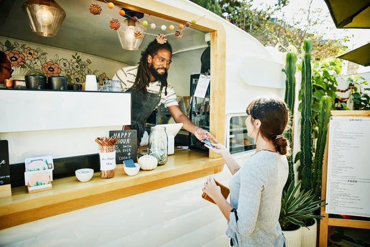 woman paying food truck owner with credit car.width aTVnc.jpg