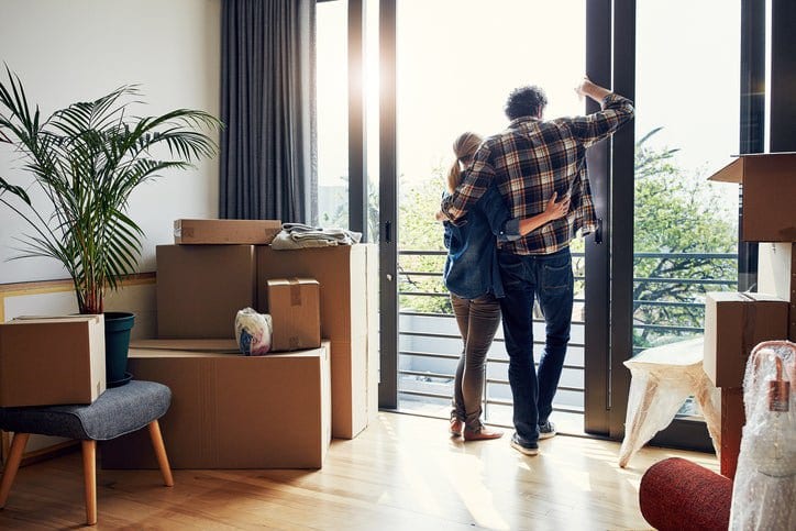 couple at window with moving boxes in new hom.width VeumdPo.jpg