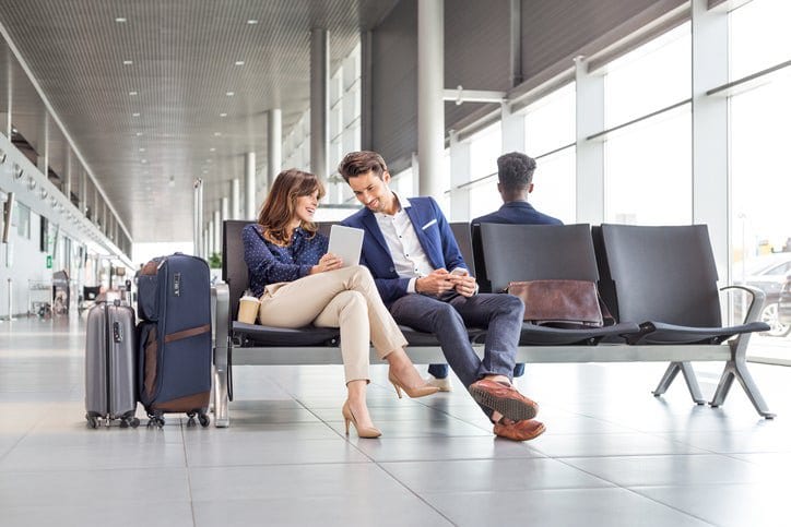 man and woman sitting at airport opGWJ.width .jpg