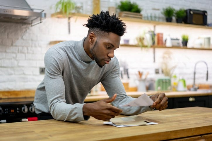 man in kitchen opening mail ecOhBNj.width .jpg