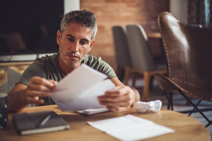 man with bills at desk fggd.width .jpg