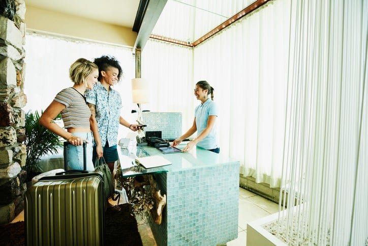 two women checking into hotel VFnxxdU.width .jpg