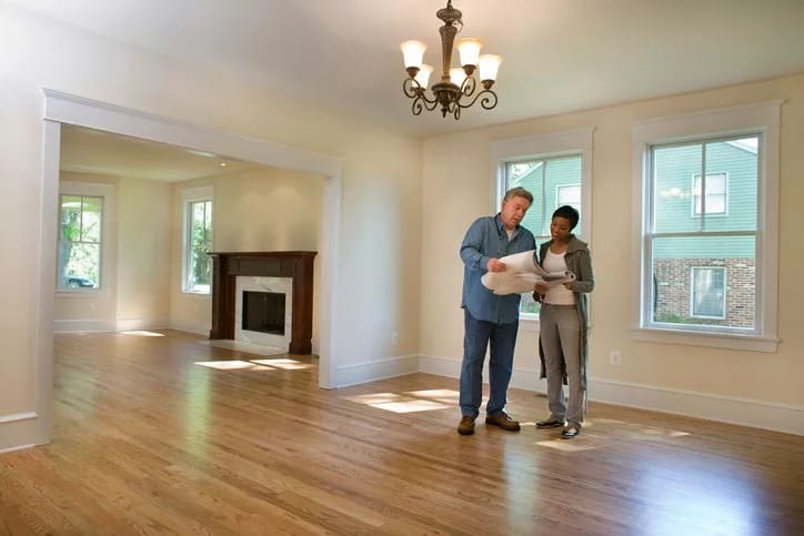 man and woman with blueprints in empty house .width .jpg