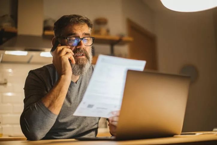 man on phone with paper and laptop KarxXs.width .jpg
