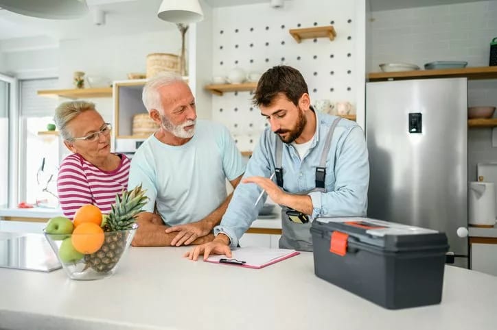 repairman talks to couple in kitchen KLkHSy.width .jpg