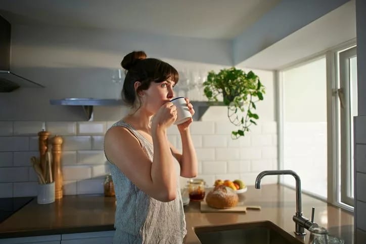 woman drinking tea in kitchen fauhDGH.width .jpg