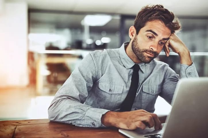 bored man working at computer at office job.width .jpg