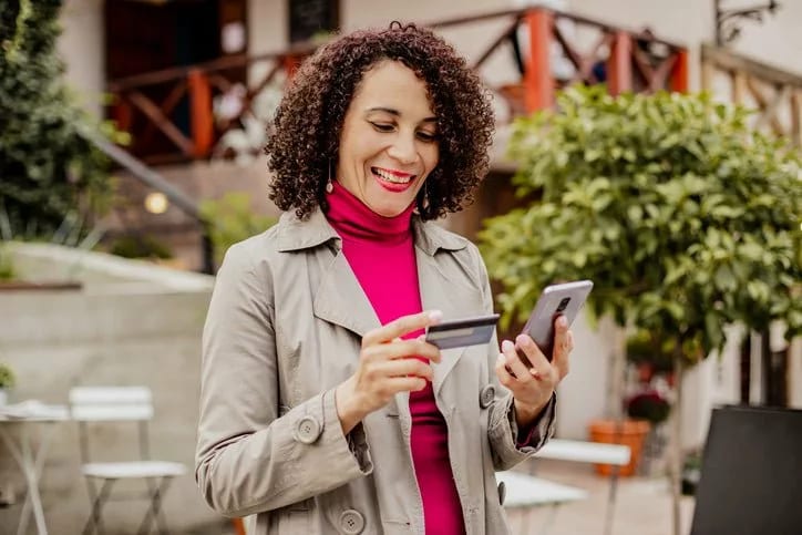 woman holding credit card and phone vpiLZ.width .jpg