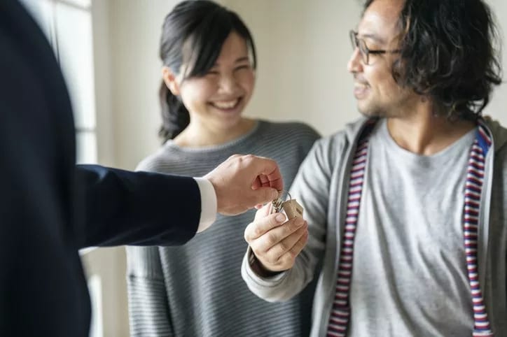 realtor handing couple house keys.width .jpg