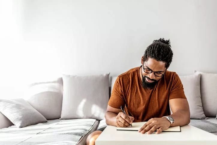 man on couch writing in notebook YuEdzZp.width .jpg