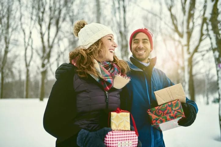 couple outdoors with holiday gifts.width .jpg