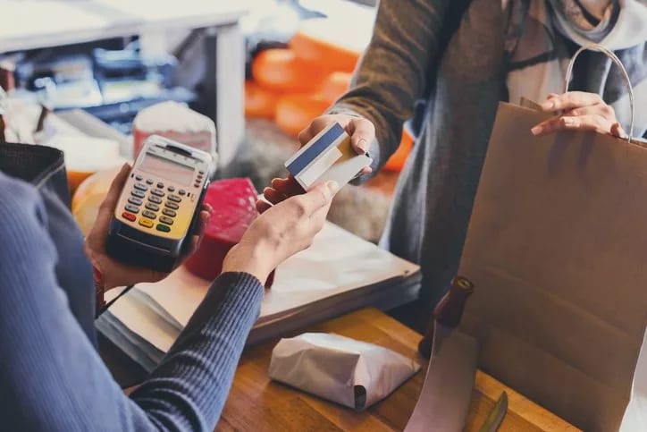 handing credit card to shop cashier.width .jpg
