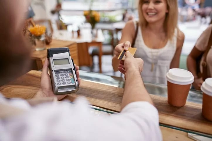 woman handing credit card to cofee shop cashi.width .jpg