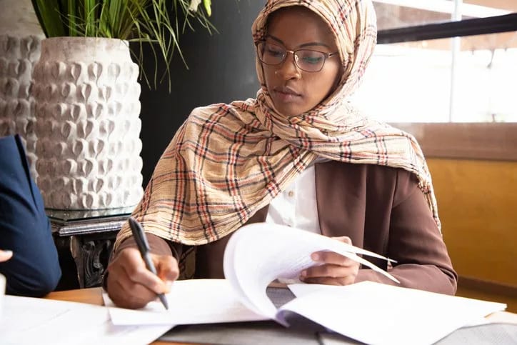 woman signing paperwork in office.width .jpg