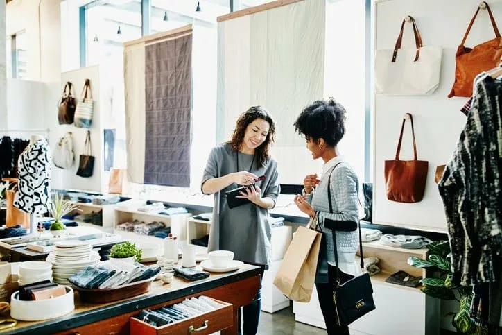 two women swiping credit card in store tjKpb.width .jpg