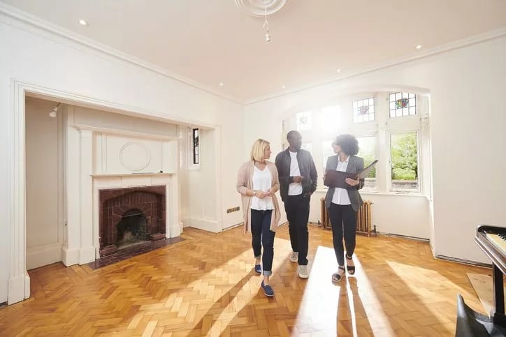 couple with realtor in empty living room.width .jpg