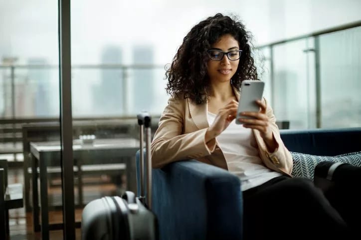 woman with suitcase and phone lalcl.width .jpg