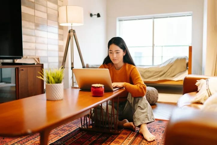 woman on living room floor with laptop.width bGokC.jpg