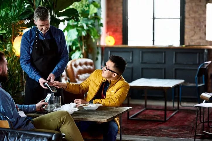 man paying in restaurant with credit card BH.width .jpg