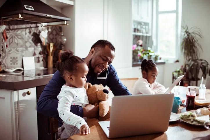 dad on phone with daughters at kitchen table .width .jpg