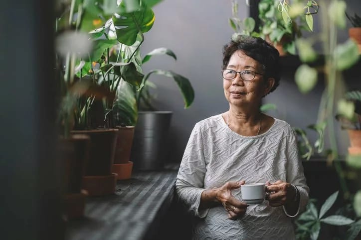 woman drinking tea near houseplants rpwlRul.width .jpg