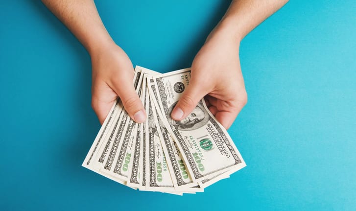 person holding hundred dollar bills copy .jpg